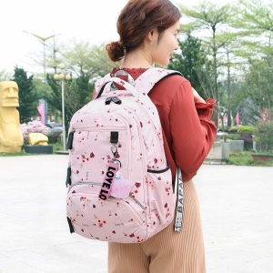 Mochila escolar rosa con motivos florales para niñas, llevada por una niña