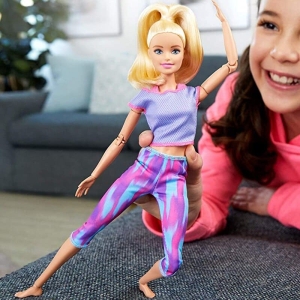 Muñeca de fitness para niñas estilo Barbie interpretada por una niña en una casa