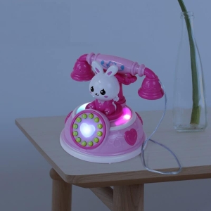 Teléfono de juguete para niñas, colores rosas sobre una mesa en una casa