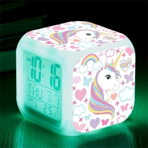Reloj digital unicornio para niñas sobre una mesa