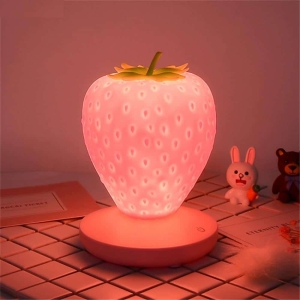 Luz de noche LED con forma de fresa para niñas. Buena calidad y muy original sobre una mesa en una casa
