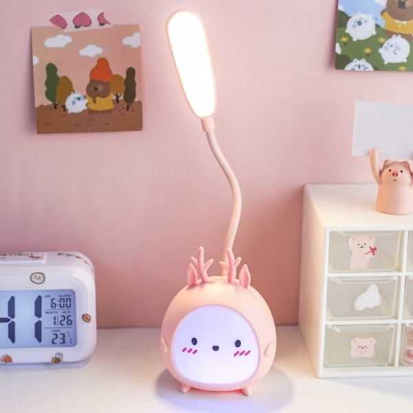 Luz de noche LED de conejito rosa para niñas sobre una mesa junto a un reloj.