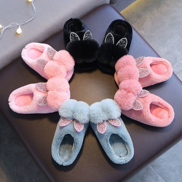 Zapatilla de niña con doble pompón en una silla varios colores