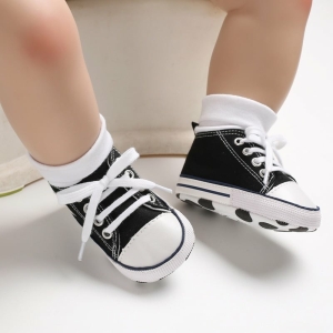Zapatillas negras de caña alta con cordones llevadas por un niño