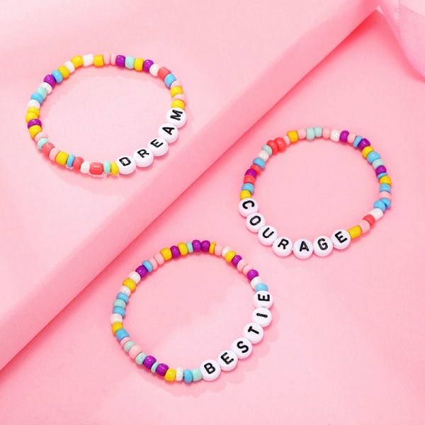 Pulsera de cuentas con letras de colores para niña sobre fondo rosa
