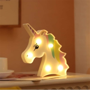 Luz de noche LED de unicornio para el dormitorio de una niña sobre una mesa en una casa