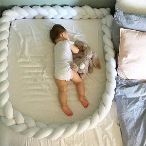 Protector de cuna para la cuna de una niña en una cama con un bebé dentro en una casa