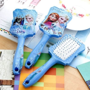 Cepillo azul Snow Queen para niñas sobre una mesa con un cuaderno