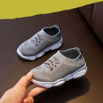 Un par de zapatillas grises antideslizantes cogidas de la mano de un adulto