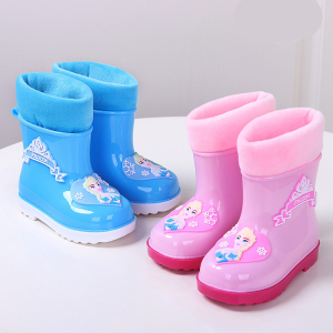 dos botas de lluvia para una niña, una azul y otra rosa, ambas con un dibujo de Frozen, están colocadas sobre una mesa blanca