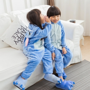 Traje de pijama de vellón azul de dibujos animados para niñas llevado por una niña y un niño en una silla en una casa