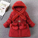Chaqueta roja de chica con capucha, tirada en un suelo gris con una revista abierta al lado