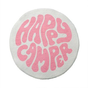 Una alfombra redonda para un dormitorio de niña blanco y rosa. Con la inscripción happy camper en el centro.