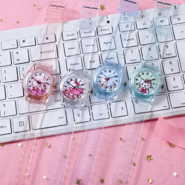 encima de un teclado, cuatro relojes translúcidos con un gatito en la esfera: blanco, rosa, azul y verde