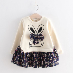 Vestido para niña presentado en una percha la parte de arriba es beige con una simpática cabeza de animal con un lazo y la parte de abajo es azul oscuro