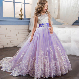 Vestido largo morado de tul con cola llevado por una niña en un dormitorio