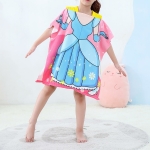 Toalla de playa para niña con diseño de princesa, llevada por una niña de pie sobre una alfombra gris