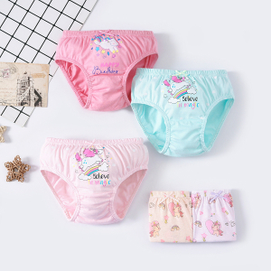Conjunto de cinco bragas sobre fondo claro, que incluye un par de bragas rosa oscuro en la parte superior con un diseño de un unicornio con cola multicolor, estrellas de colores y Feliz cumpleaños, un par de bragas azules y un par de bragas rosa pálido en la parte inferior, ambas con un diseño de un unicornio corriendo sobre un arco iris y estrellas y nubes, y dos pares de bragas dobladas en la parte inferior con varios unicornios en un diseño, arco iris, diamante y corazón.