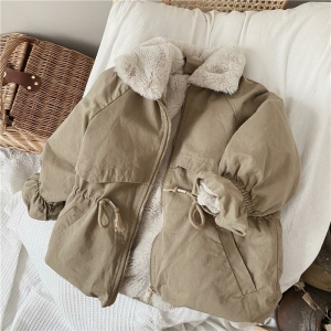 Parka forrada de beige sobre un elemento blanco en una habitación