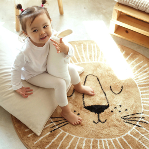 Alfombra de habitación de bebé de estilo nórdico en forma de león para niña con una niña sobre la alfombra