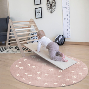 Bebé jugando en una alfombra redonda en un dormitorio