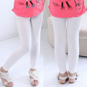 Piernas delanteras y traseras de una niña con leggings blancos, camiseta rosa y sandalias