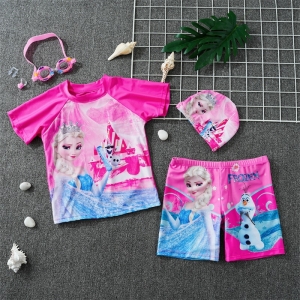 Camiseta y bañador rosa de Snow Queen tumbados sobre un suelo gris con gorro y gafas de natación