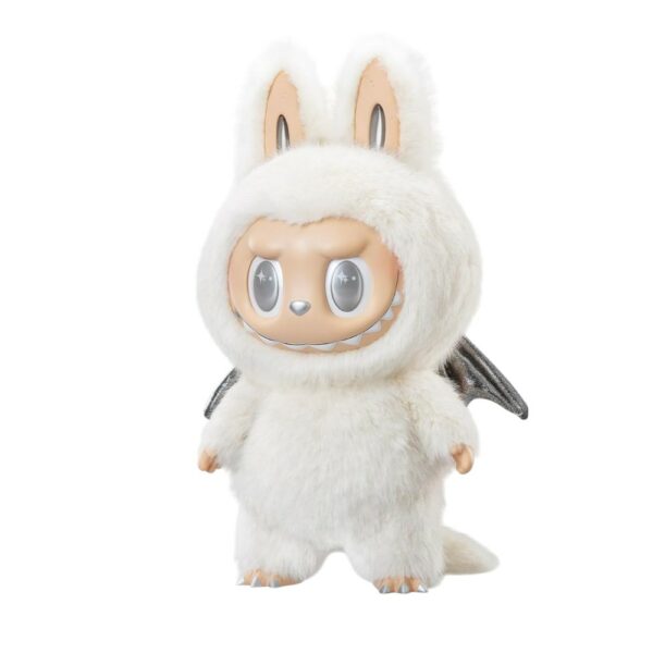 Peluche Labubu blanca con alas plateadas y ojos brillantes, de pie sobre un fondo celeste luminoso