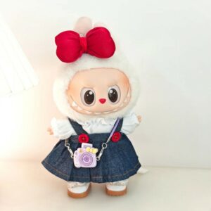 Peluche Labubu blanca con conjunto de vestido vaquero, blusa blanca y gran lazo, sobre fondo neutro