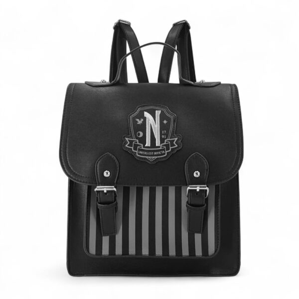 Mini mochila negra Miércoles Addams con escudo Academia Nunca Más, sobre fondo blanco.